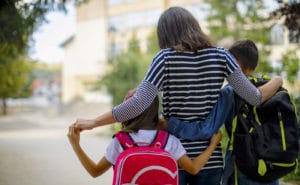 Mother taking kids to school.