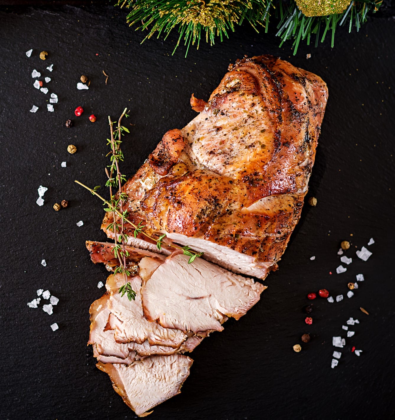 Roasted sliced Christmas turkey on dark rustic background. Top view. Festival food.