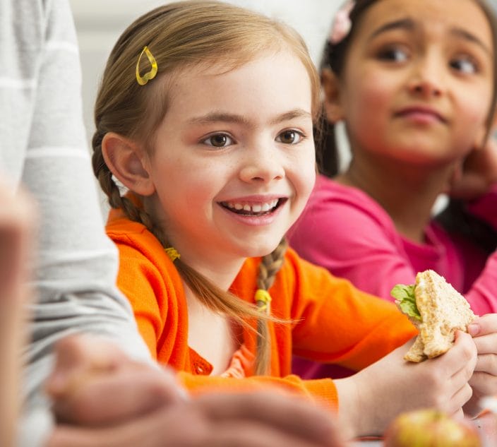 Young girl eating packed lunch at school.