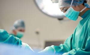 A surgeon performing surgery on a patient after receiving anesthesia.